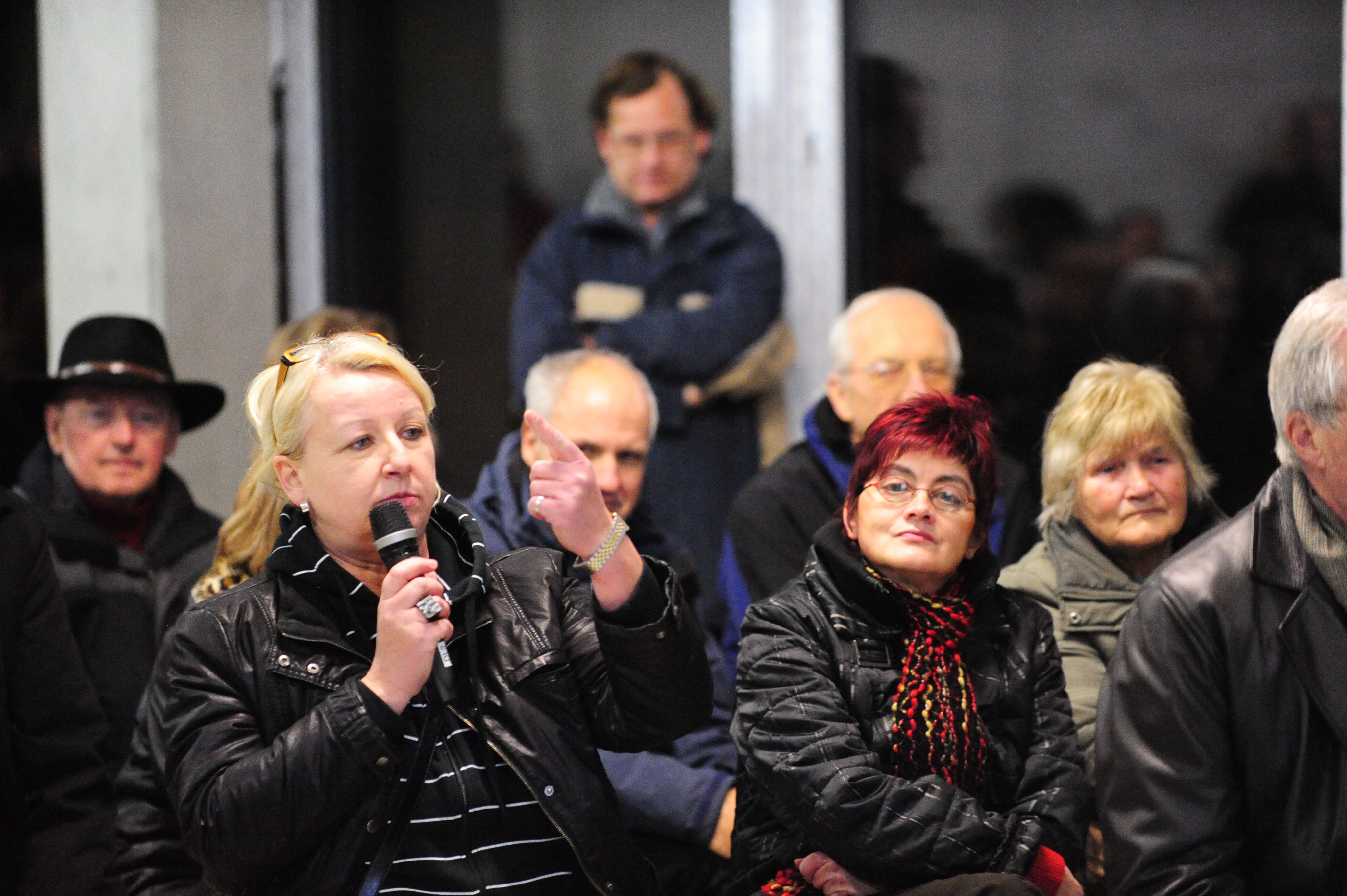 Woman speaking into a microphone in an audience