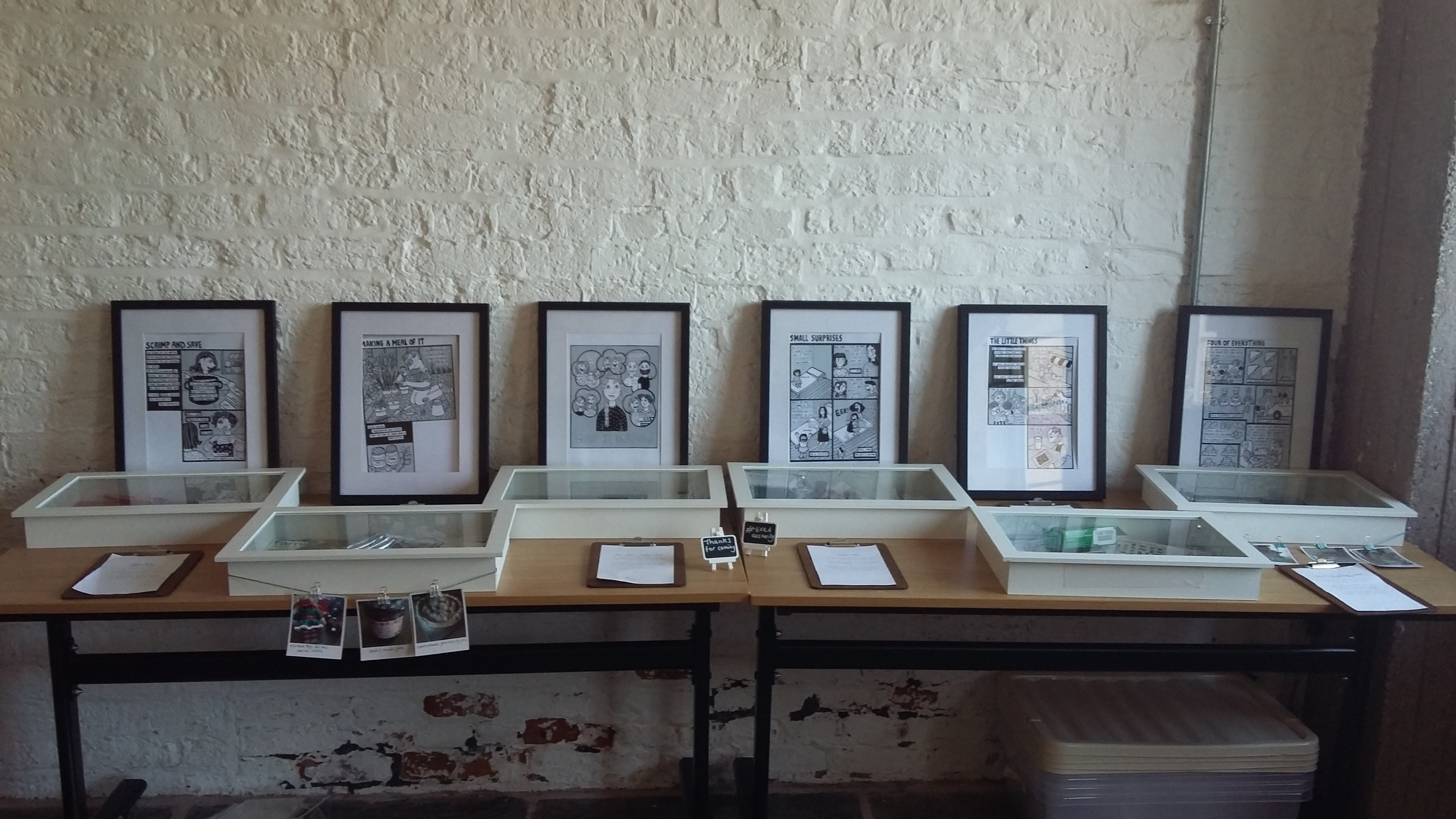 A photo from an art exhibition of framed pieces of work on a table